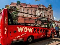 A red Krakow Sightseeing Bus with people hopping on
